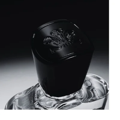 Close-up of a black bottle cap with an embossed crest logo above a clear glass bottle neck.