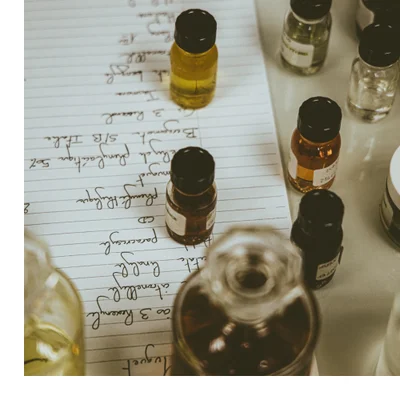 A Creed Royal Oud perfume bottle is displayed on black leather equestrian gear including a saddle and bridle, with visible text CREED ROYAL OUD DE PERE EN FILS DEPUIS 1760 FROM FATHER TO SON SINCE 1760 100ML 3.33 FL. OZ.