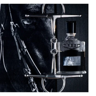 A bottle of Creed Aventus cologne is shown next to a horse bit, with the eye of a horse in the background, featuring the text CREED and AVENTUS.