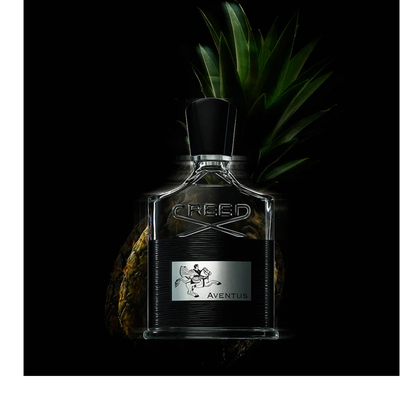 A striking display of five Creed Aventus fragrance and body products, including a black perfume bottle, a golden hand cream tube, two tall golden pump bottles, and a creamy bar of soap, emerges from golden liquid splashes on a reflective black background, with visible text including CREED, 1760, AVENTUS, HAND CREAM, CREME MAINS, HAND & BODY LOTION, LOTION MAINS ET CORPS, HAND & BODY WASH, and LAVANT LIQUIDE MAINS ET CORPS.