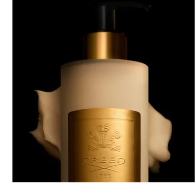 Creamy white pump bottle with black pump and gold collar, a blob of lotion at its base and embossed text 'CREED 1760'.